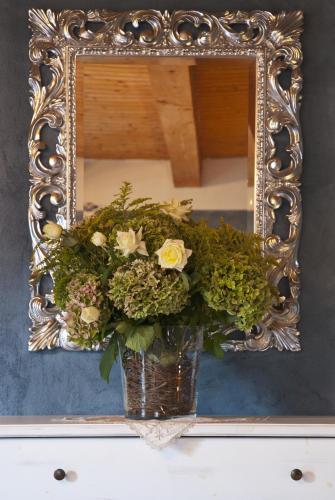 a vase filled with flowers in a mirror at Ca' Baetti l'Antica Corte in Roncola