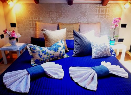 a bed with blue sheets and pillows with bows at A Trecastagni - Etna Home in Trecastagni