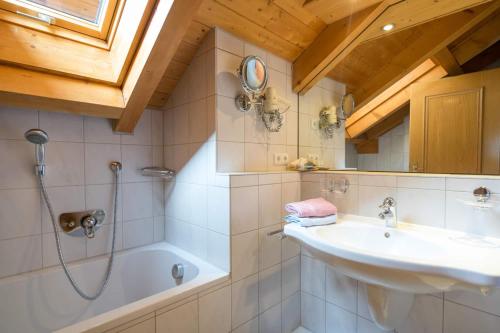 ein Badezimmer mit einem Waschbecken, einer Dusche und einer Badewanne in der Unterkunft Landhaus Barbara Ferienwohnungen in Oberstdorf