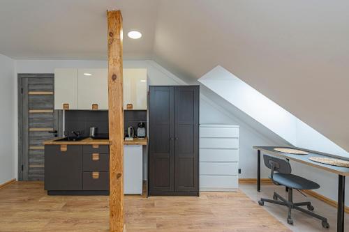 une cuisine mansardée avec un bureau et un escalier dans l'établissement Central Studio Apartments by Hostlovers, à Kaunas