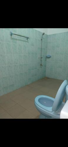 y baño con aseo azul y ducha. en Studio meublé, en Abomey-Calavi