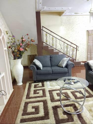 sala de estar con sofá azul y mesa de cristal en Studio meublé en Abomey-Calavi