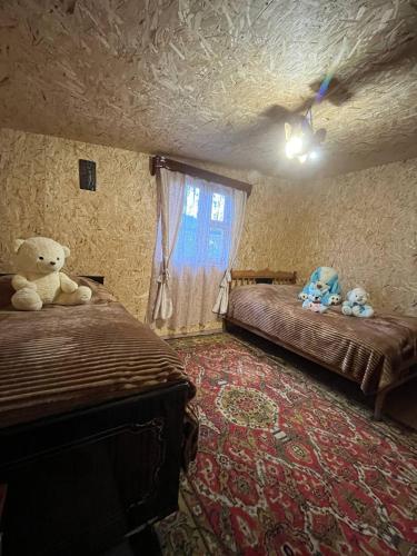 a bedroom with two beds and a teddy bear at Sivil&Sed in Hartʼagyugh