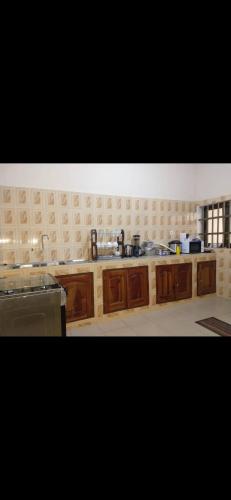 La cuisine est équipée de placards en bois et d'un four avec plaques de cuisson. dans l'établissement Studio meublé, à Abomey-Calavi