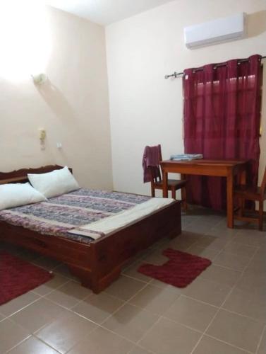 1 dormitorio con cama y escritorio. en Studio meublé en Abomey-Calavi