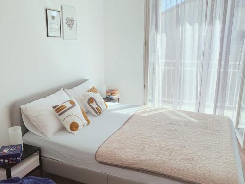 een slaapkamer met een bed met witte kussens en een raam bij Apartment Jukich in Sveti Filip i Jakov