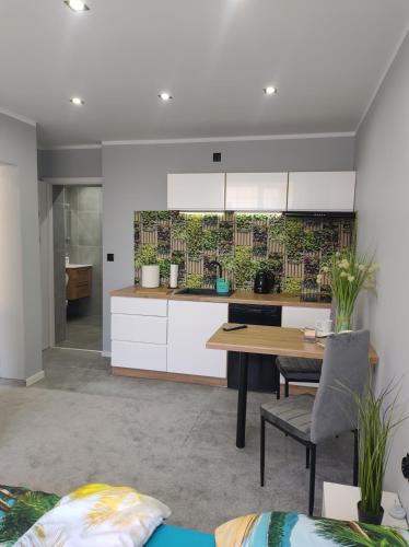 a kitchen with white cabinets and a wooden table at Pokoje gościnne U Bosmana in Dźwirzyno