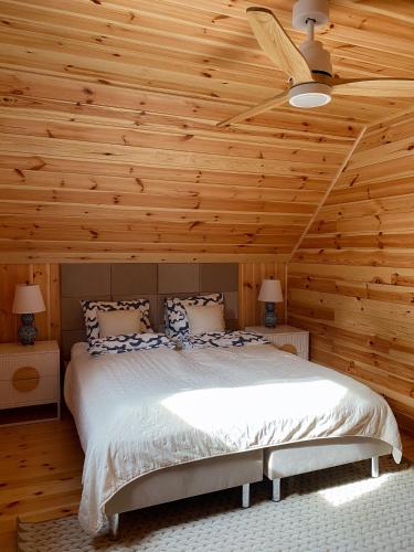 a bedroom with a bed with a wooden ceiling at Sielskie Chatki in Sandomierz