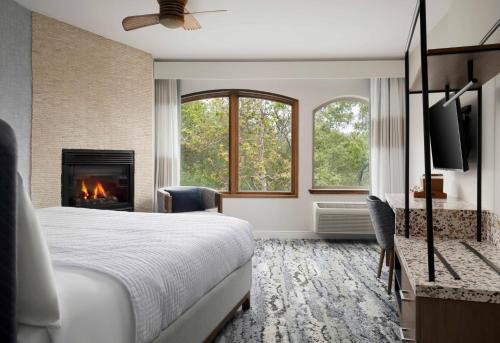 a hotel room with a bed and a fireplace at El Colibri Hotel & Spa in Cambria