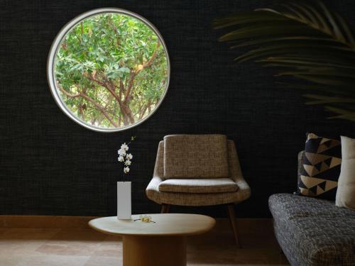 a living room with a chair and a round window at El Colibri Hotel & Spa in Cambria