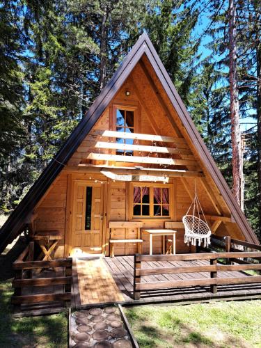 a cabin in the woods with a gambrel roof at Vikendica Šumski Dragulj in Bajina Bašta