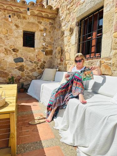 a woman sitting on a bed in a room at B&B La Vista Brava in Platja  d'Aro