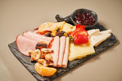 a plate of different types of cheese and fruit at Hotel Atlante Plaza in Recife