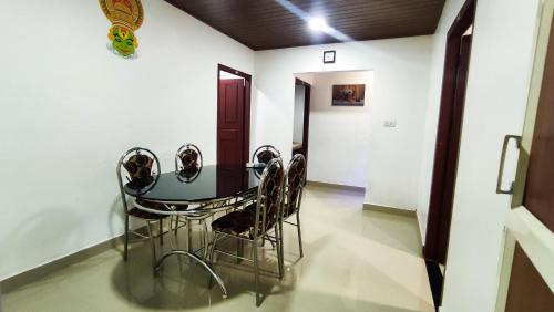 Habitación con mesa y 4 sillas en Munnar Valley View Annex, en Munnar