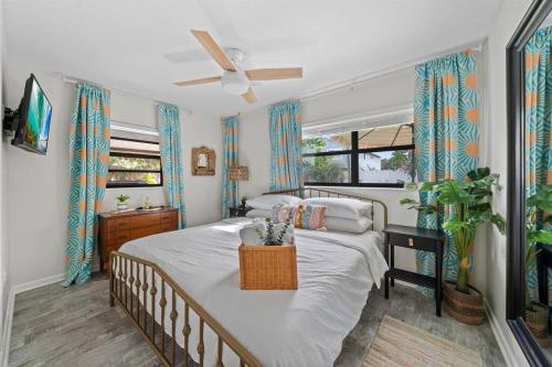 a bedroom with a large bed with a fan at Lunar Beach Bungalow in Cocoa Beach