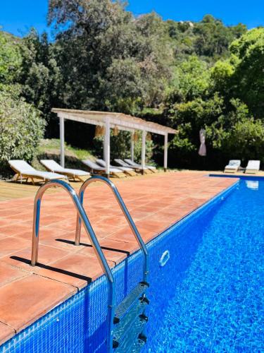 a swimming pool with chairs and a gazebo at B&B La Vista Brava in Platja  d'Aro