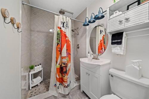 a bathroom with a shower curtain and a toilet at Lunar Beach Bungalow in Cocoa Beach