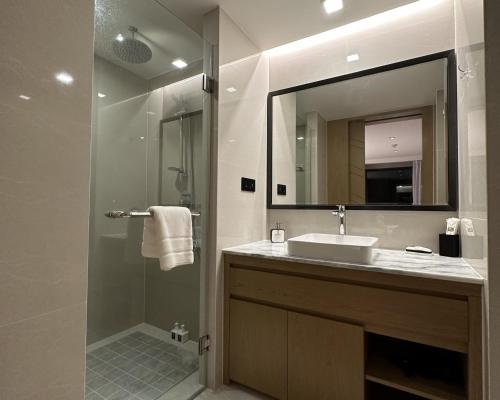 a bathroom with a sink and a shower with a mirror at La Vita Phuket Rawai in Rawai Beach