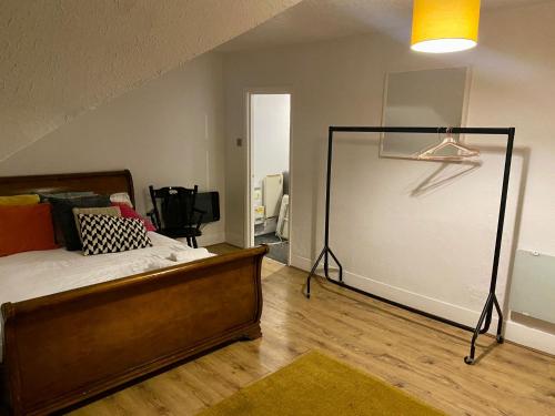 1 dormitorio con cama y pared blanca en Thornton Heath Studios - Sleeps 2, en Thornton Heath