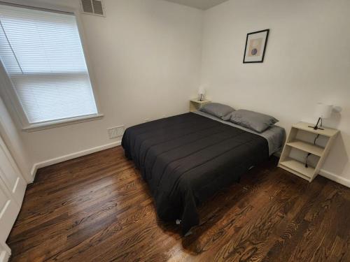een slaapkamer met een bed en een houten vloer bij Close to NYC - 3BD Spacious and Secluded apt in Jersey City