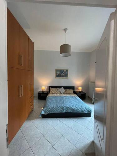 ein Schlafzimmer mit einem Bett, zwei Tischen und zwei Lampen in der Unterkunft Private Spacious Apartment in Athen