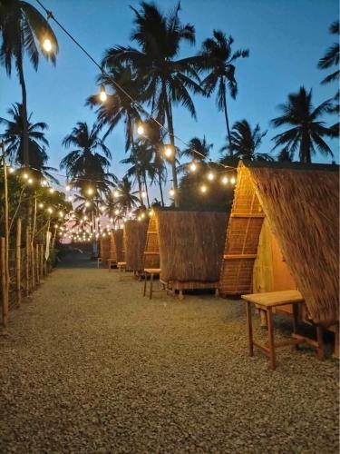 una fila de sillas en una playa por la noche en Patar Palms, en Bolinao