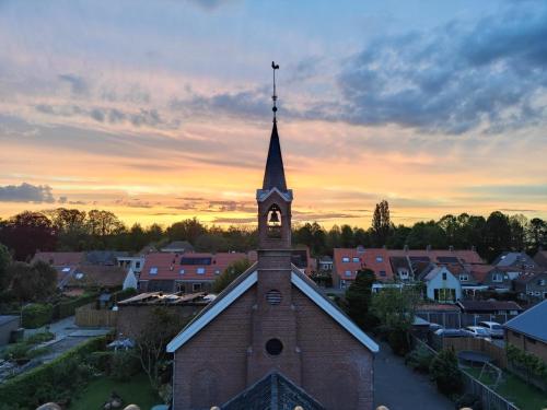 a church with a clock tower in a small town at Hotel Willemstad in Willemstad