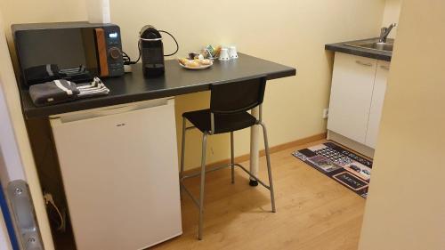 une cuisine avec un bureau, un four micro-ondes et une chaise dans l'établissement Chambre avec cuisine indépendante à 25 min du capitole, à Auzeville-Tolosane