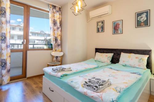 a bedroom with a bed and a window at Joy Apartment Burgas center private parking in Burgas