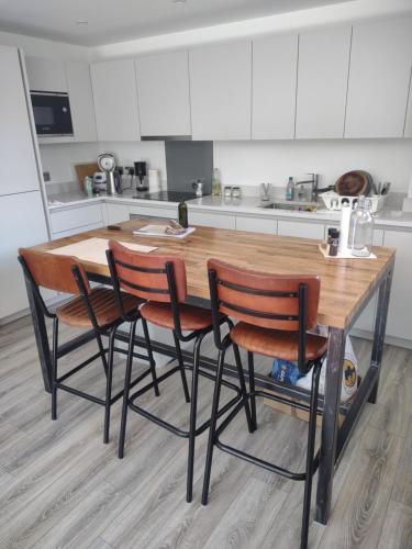 a kitchen with a wooden table and four chairs at Modern flat shared with host, park view in Clapton in London