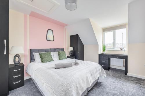 a white bedroom with a large bed and a desk at 3 Bed House - Contractors, Relocators & Visitors, Coffee Machine & Free Parking - Sleeps 6 in Bedford