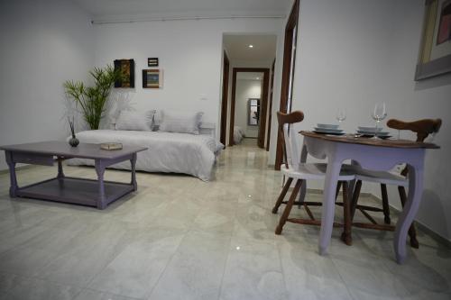 een woonkamer met een bed en een tafel bij Un ton Violet in Sfax
