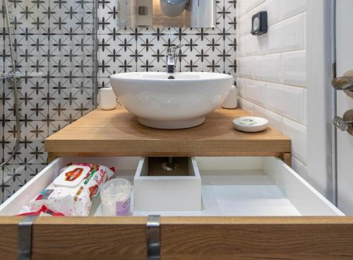 a bathroom with a bowl sink on a wooden shelf at Joy Apartment Burgas center private parking in Burgas