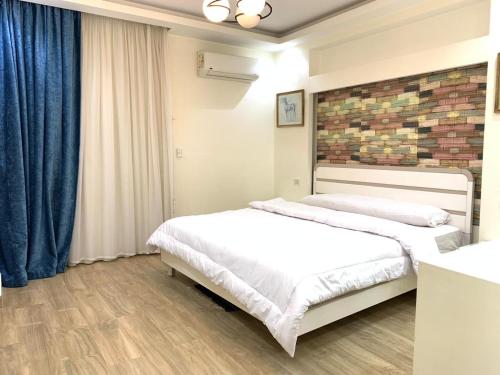 a bedroom with two beds and a brick wall at شقه فندقية للإيجار بالشيخ زايد in Sheikh Zayed