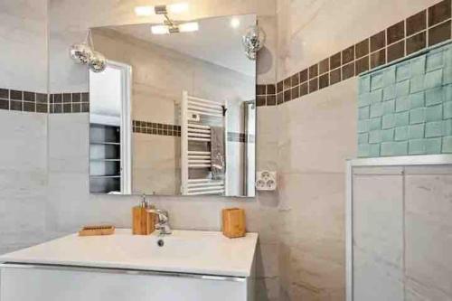 La salle de bains est pourvue d'un lavabo et d'un miroir. dans l'établissement Maison de ville contemporaine avec jardin, à Cannes