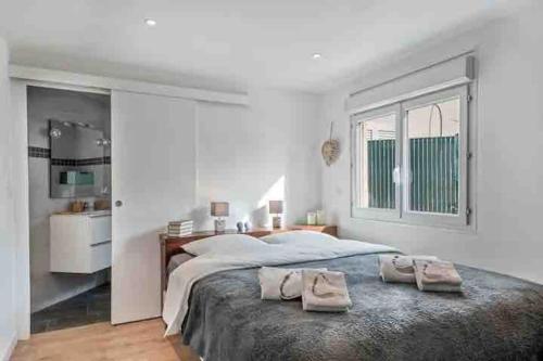 1 dormitorio con 1 cama grande y 2 toallas. en Maison de ville contemporaine avec jardin en Cannes