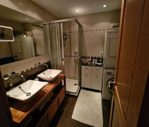 a large bathroom with two sinks and a shower at Le Serenity - bright - cozy - central in Crans-Montana