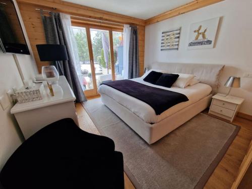 a bedroom with a large bed and a window at Le Serenity - bright - cozy - central in Crans-Montana