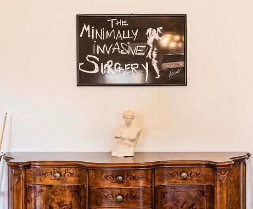 a statue sitting on top of a wooden cabinet under a poster at Windrose Prestige in Volterra