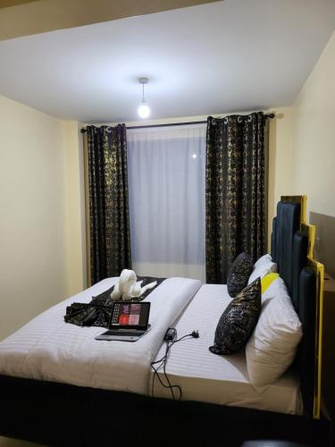 a bedroom with a bed with a laptop and pillows at G&G Homes Executive Suite in Nakuru