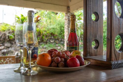 two bottles of champagne and a bowl of fruit on a table at Casa estilo cabaña “Villa Sol” en Alto Boquete in Boquete