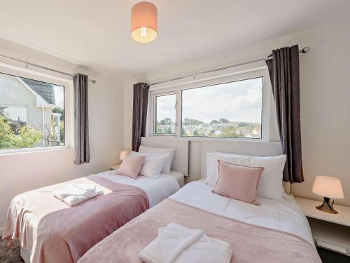 two beds in a room with two windows at 2 Bed in Ilfracombe 82615 in Ilfracombe