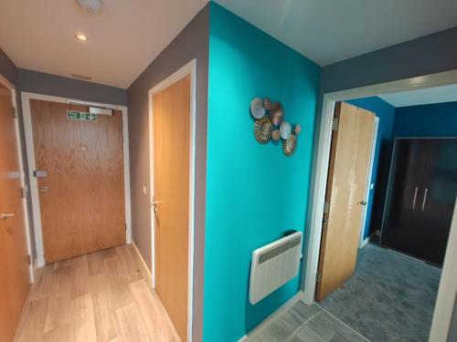 un pasillo con una pared azul y una puerta en 2br Stunning City Centre Apt en Belfast