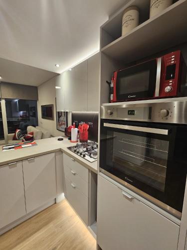 a kitchen with a microwave and a stove top oven at JOY MONTEVIDEO - Apartamento Premium - Servicios de Hotel 5 Estrellas in Montevideo