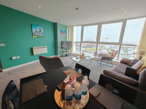 - un salon avec une table et des bouteilles d'eau dans l'établissement 2br Stunning City Centre Apt, à Belfast