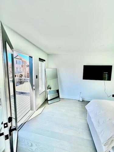 biały pokój z łóżkiem i telewizorem w obiekcie Private Luxury Full Home in Markham w mieście Markham