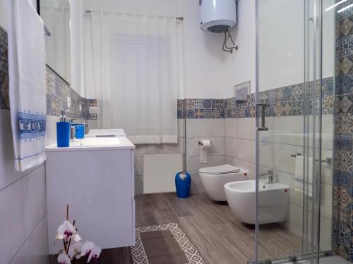 a bathroom with a toilet and a sink and a shower at Kalimera Apartment in Santo Stefano di Camastra