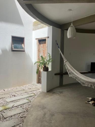 a room with a hammock in the middle of a room at Kanau Surfe e Arte in Marechal Deodoro