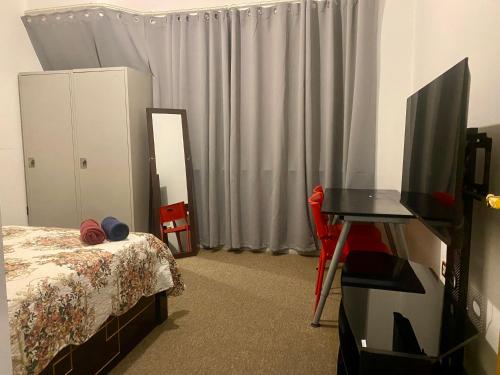 - une chambre avec un lit, une télévision et un bureau dans l'établissement A Home Away From Home, à Abu Dhabi
