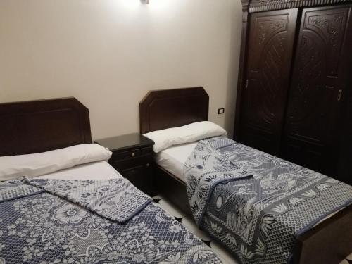 a bedroom with two beds and a dresser at Nile house in Jazīrat al ‘Awwāmīyah